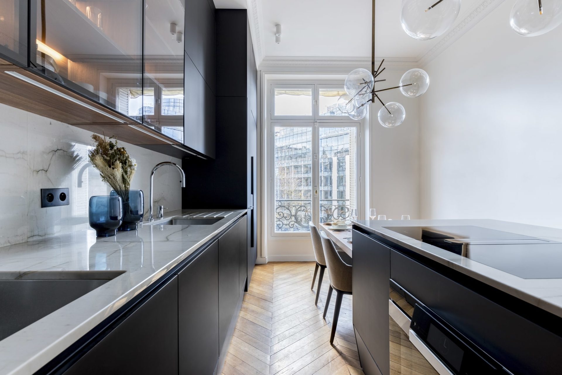 Black matte kitchen project with marble worktop and high glass-topped furniture
