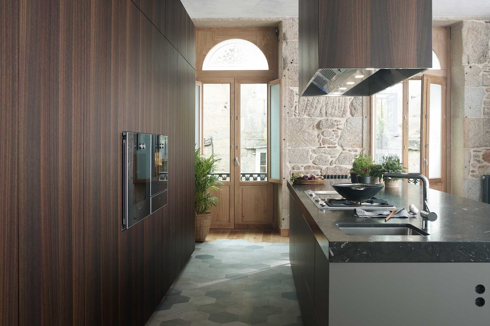 Image of wooden kitchen with practical modules and a central island with an extractor hood in the same wooden finish