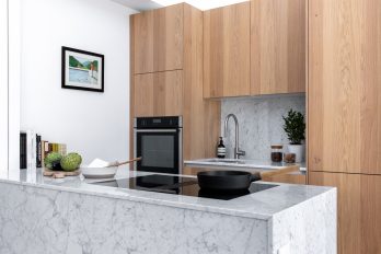 Small kitchen in light-coloured wood and details in white marble with island