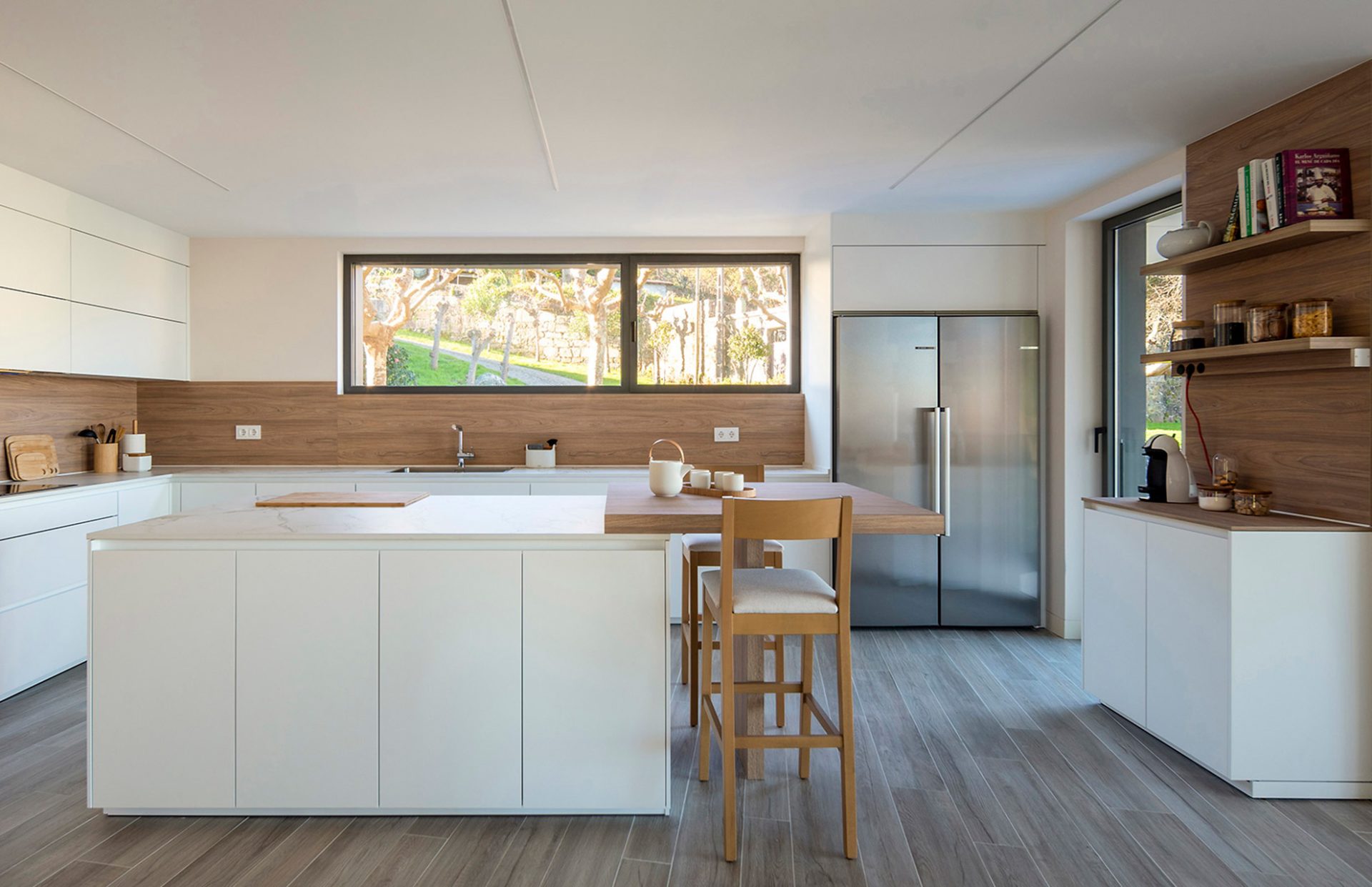 Open kitchen with central island extended by a bar table
