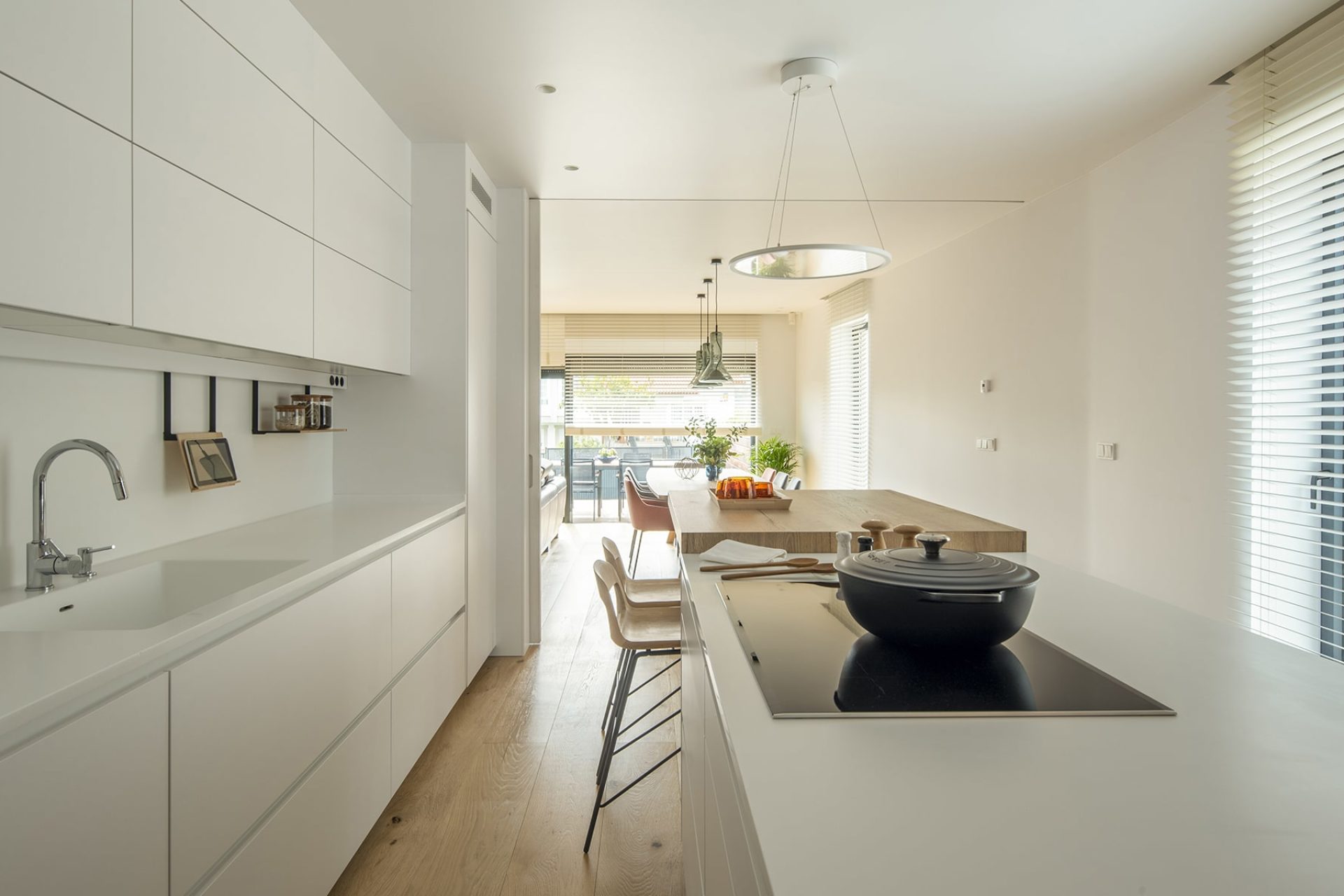 Open-plan white kitchen inspiration with island and built-in eating area