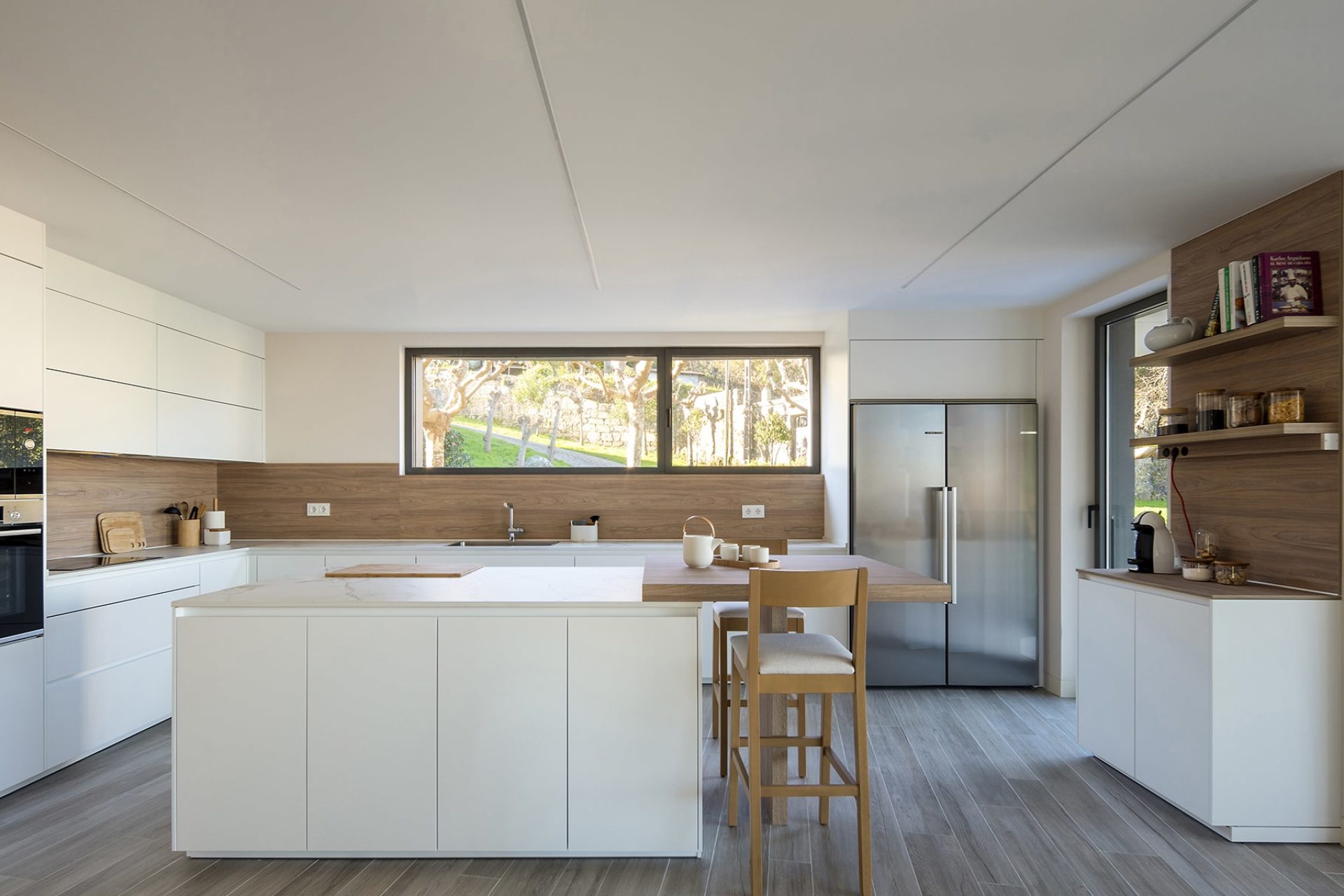Kitchen design inspiration with white facades and wooden backboard, central island and sideboard