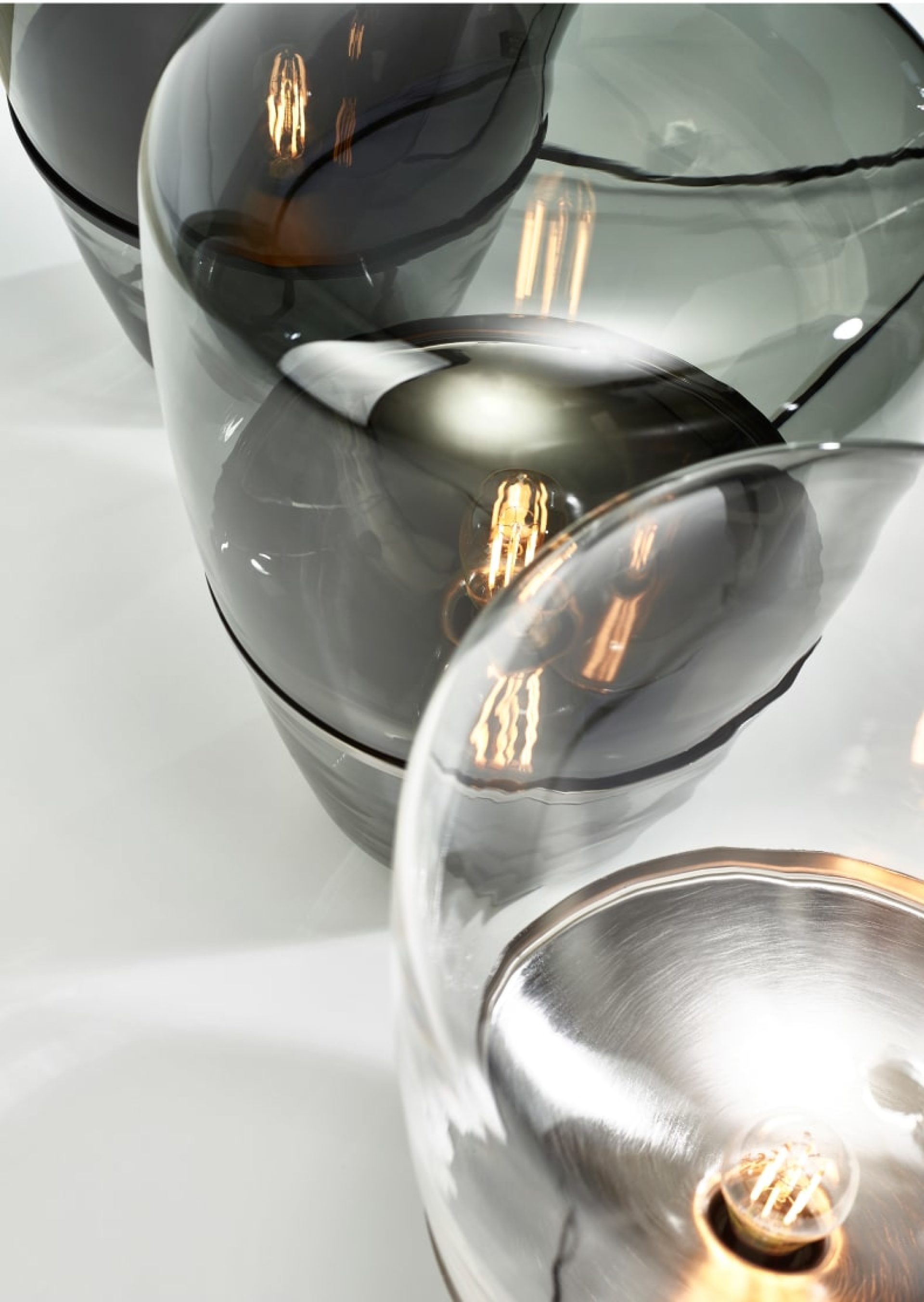 View from above of three glass Balloon lamps, with smoked and clear finishes