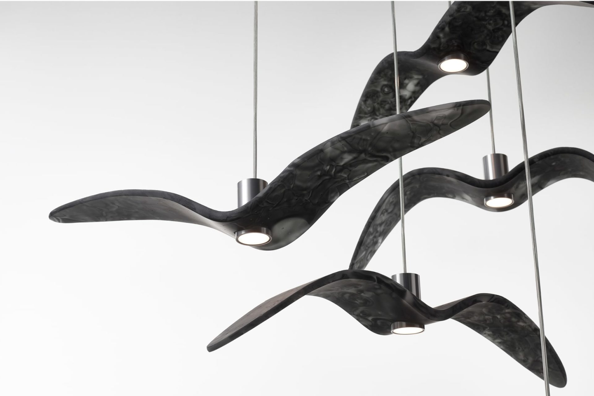 Four black pendant glass lamps in the shape of a bird