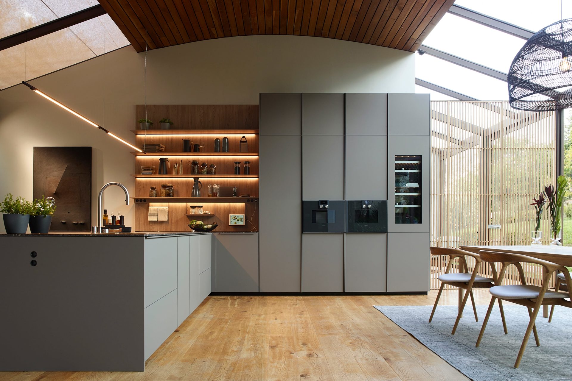 High-end L-shaped kitchen with peninsula and open shelves in wood and grey