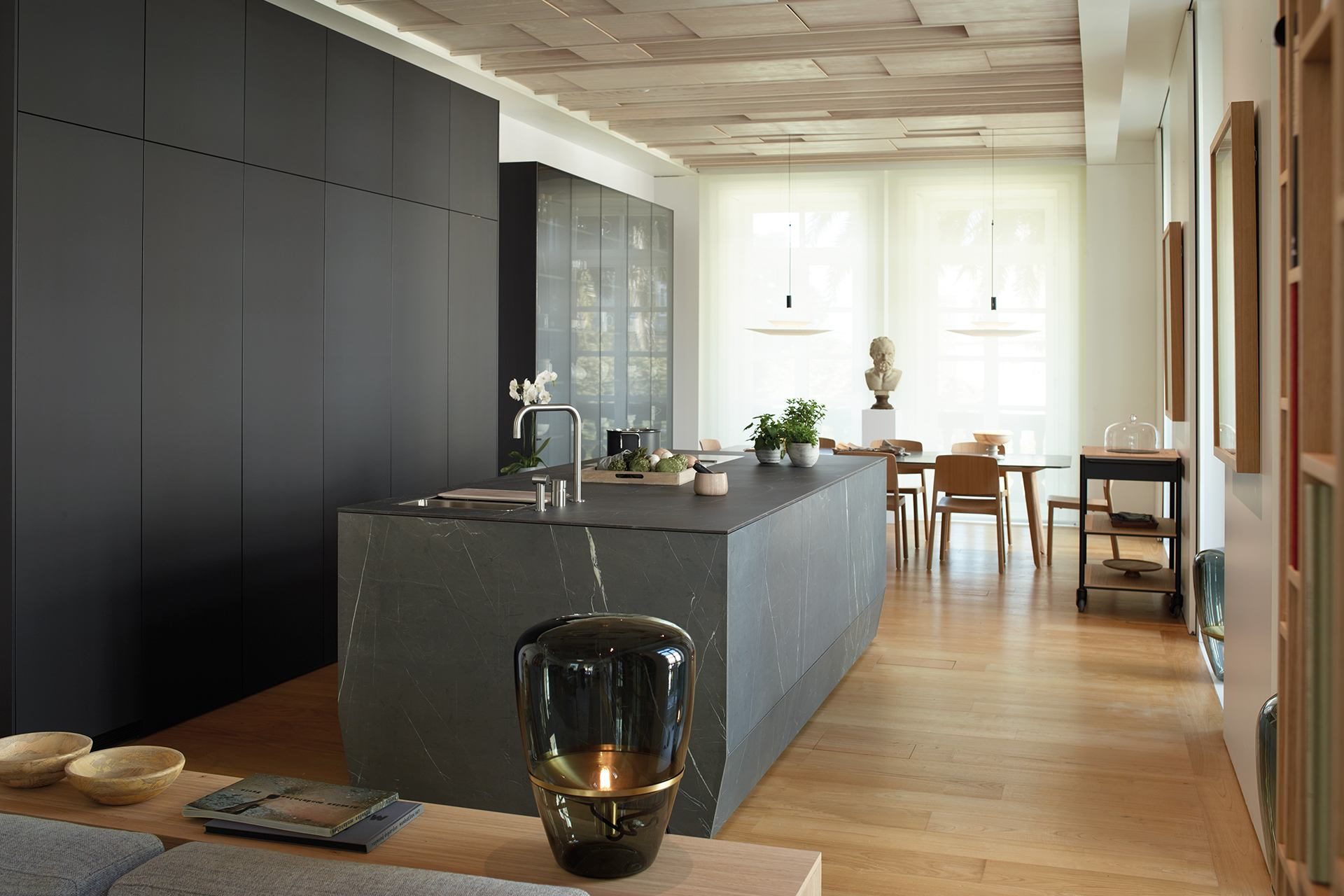  Photo of Kitchen with a linear design in black and dark grey, consisting of a central island, column units and a sideboard display cabinet