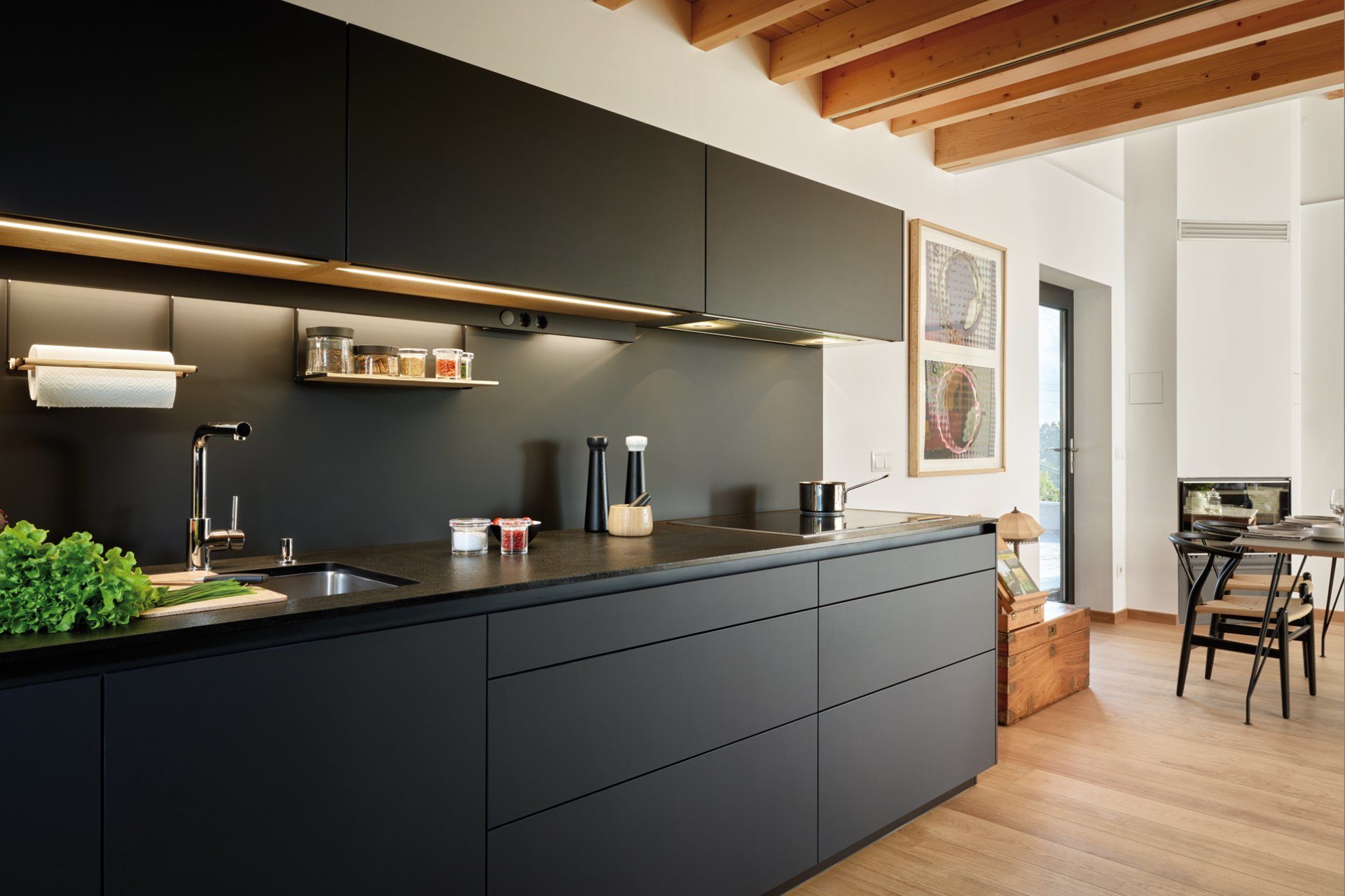 Image of kitchen composed of a worktop and black furniture with clean lines and smooth fronts
