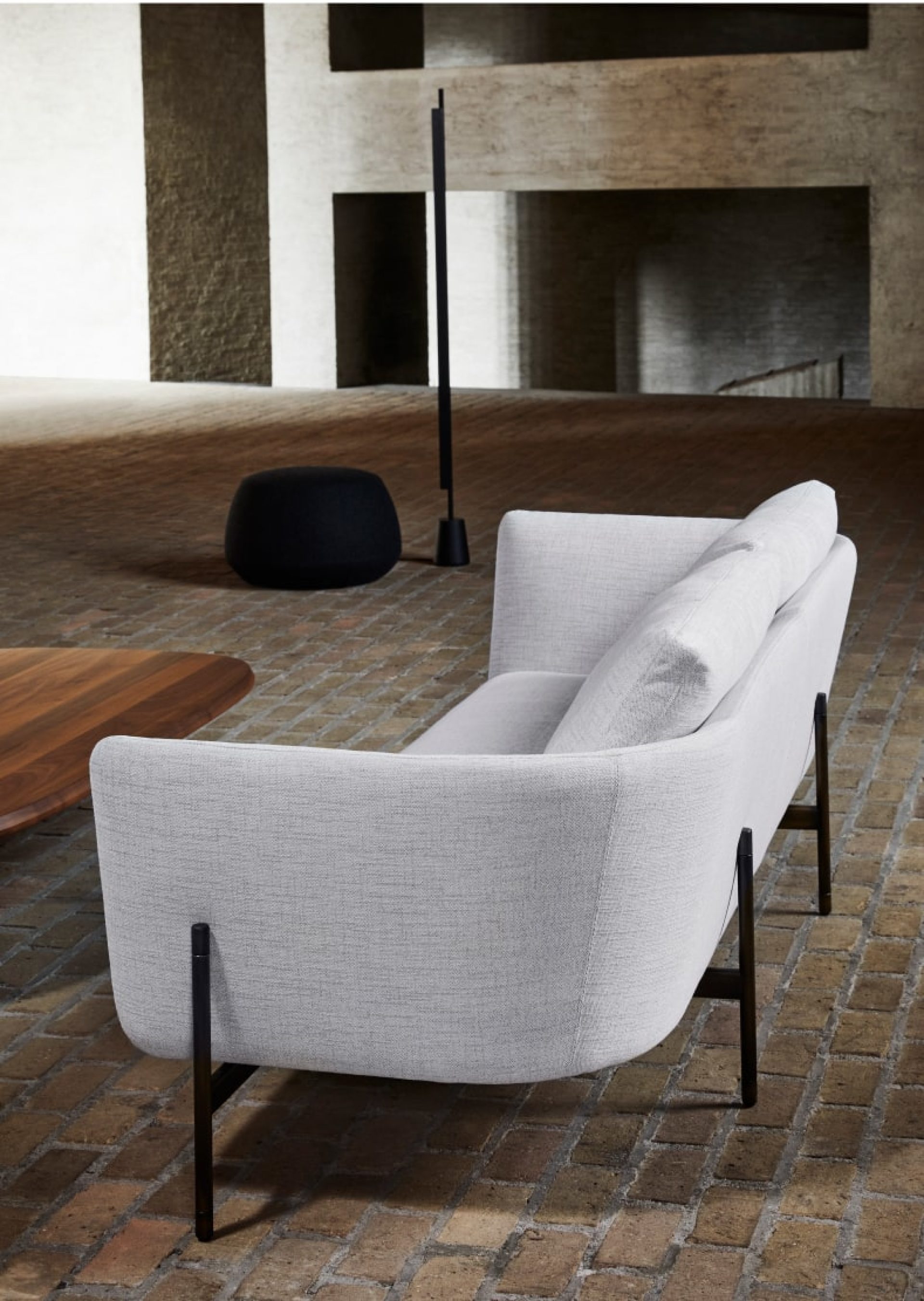 Light grey canvas sofa, black pouf and a wooden table