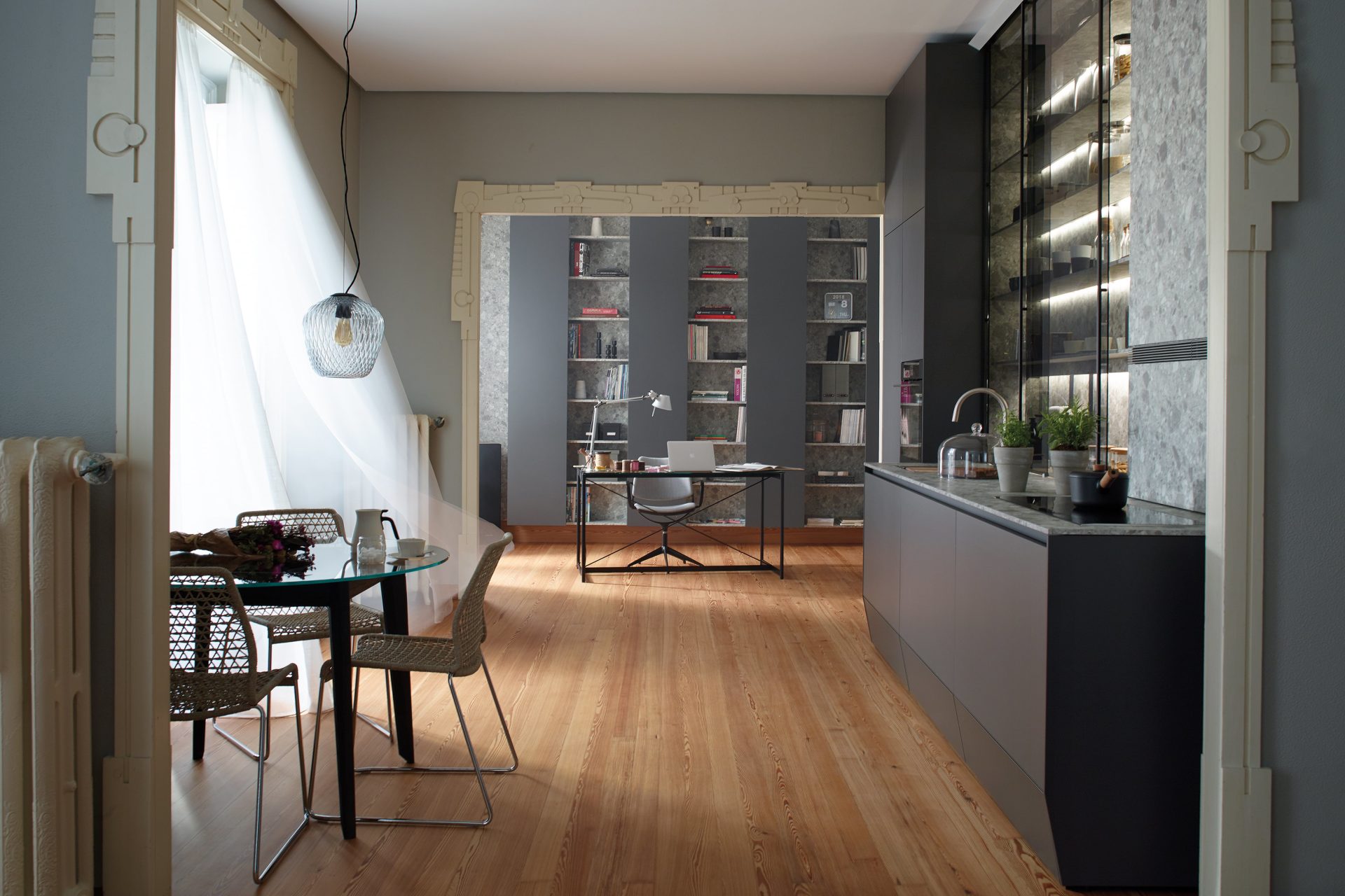 Cocina abierta con comedor y zona de despacho, con mobiliario en Gris Antracita, encimera y panel pared en Ceppo di Gré