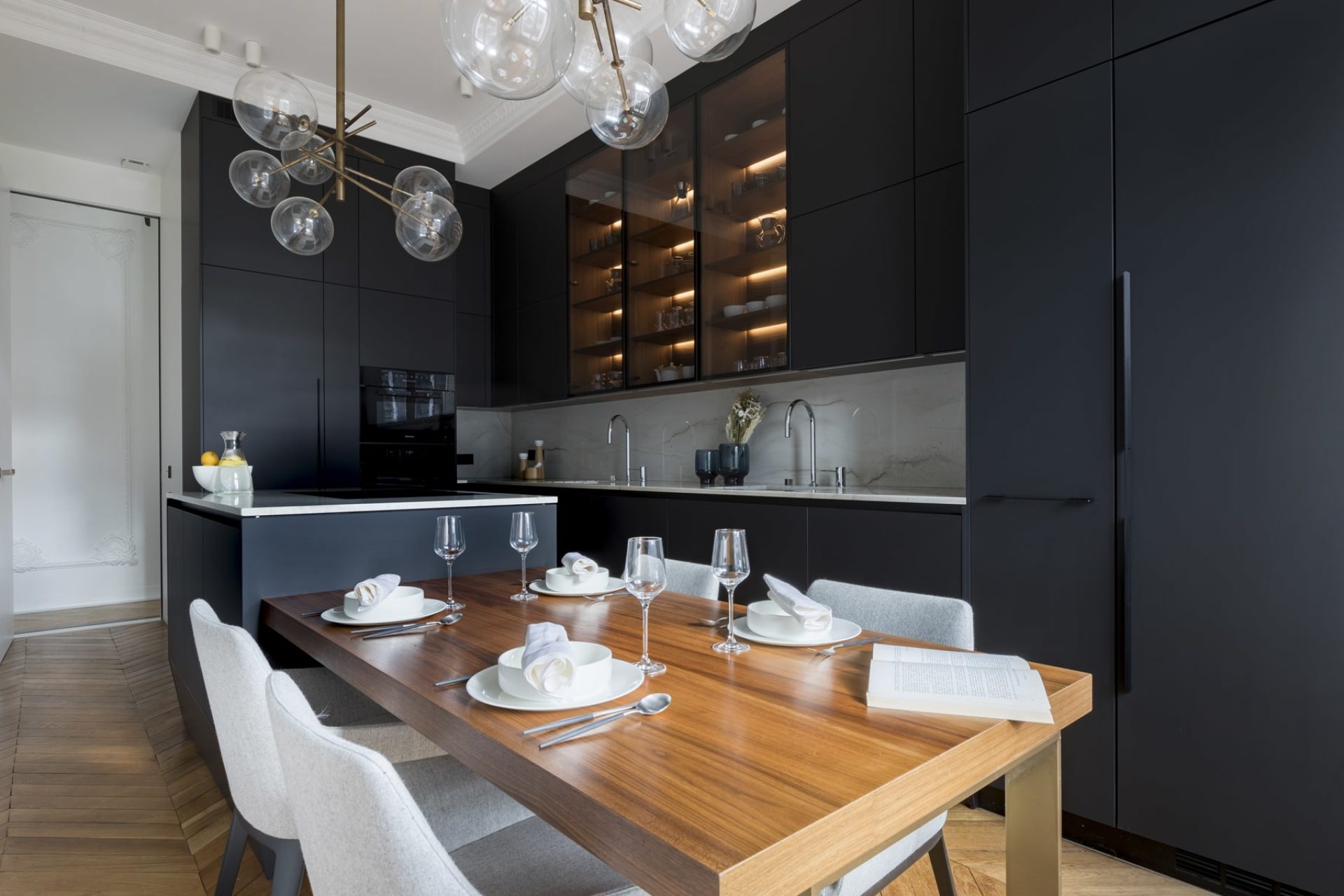 Projet de cuisine noire matte avec ilôt noir et marbre et table à manger en bois intégrée