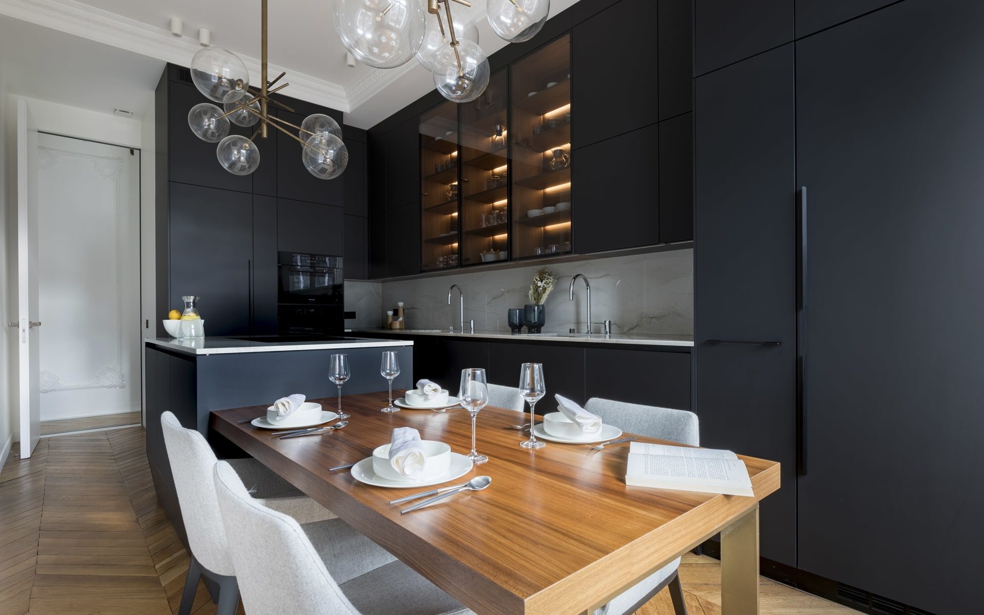 Projet de cuisine noire matte avec ilôt noir et marbre et table à manger en bois intégrée