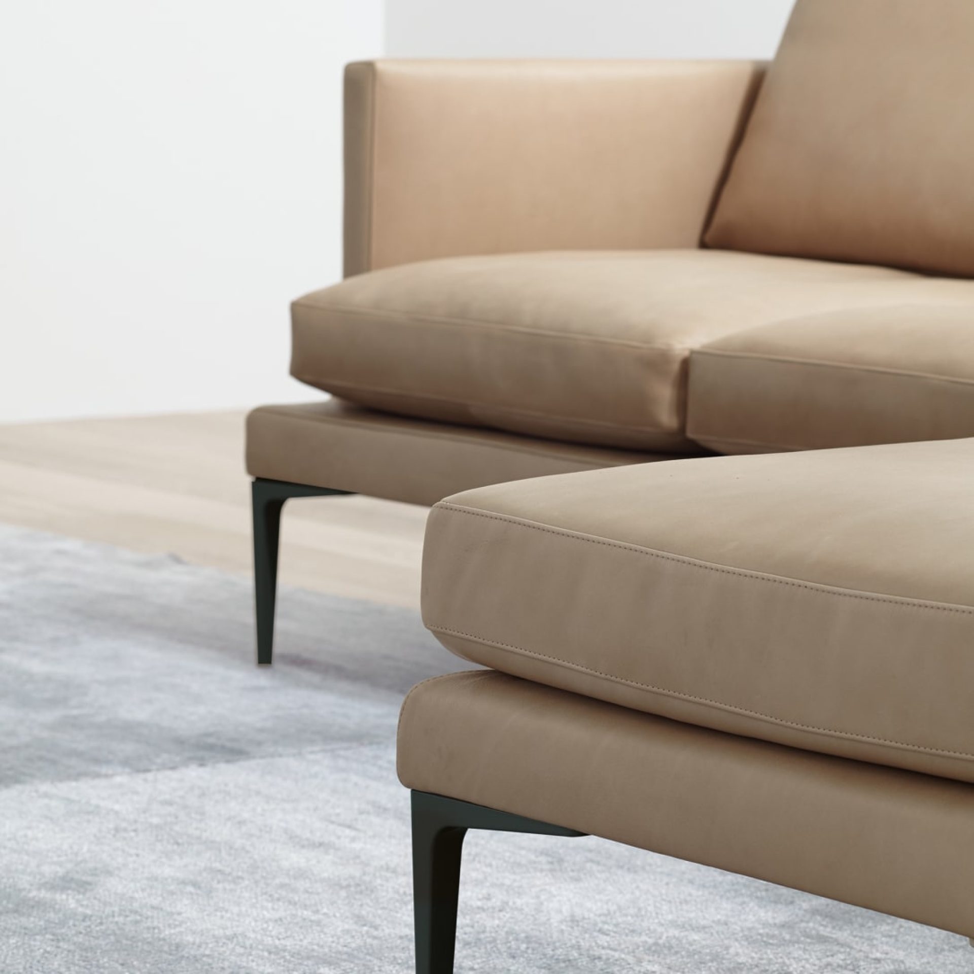 Canapé en cuir beige design avec des pattes en acier choisi par eba pour ses projets de design d'intérieurs