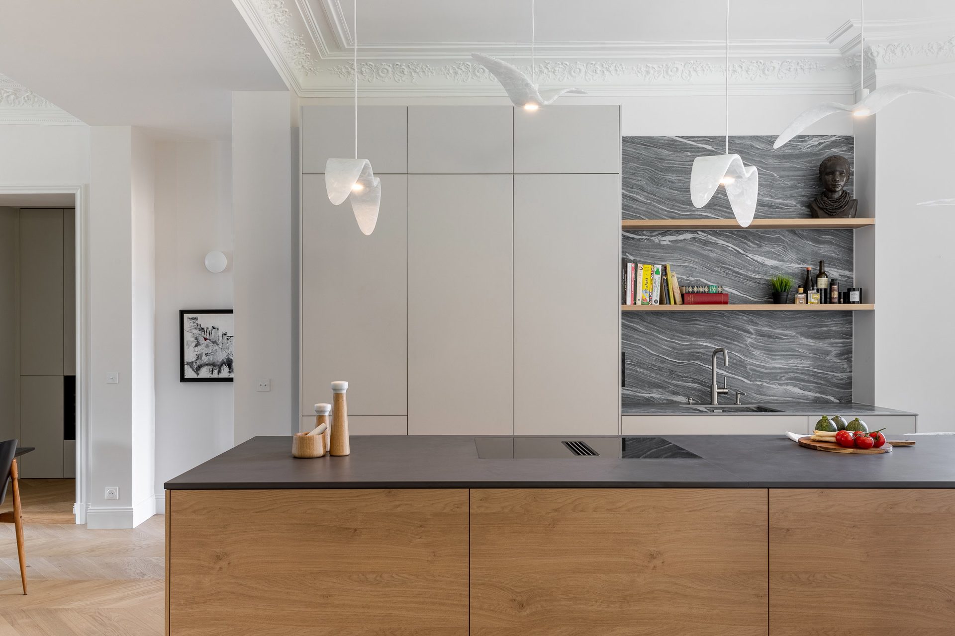 Espace cuisine ouvert avec îlot central et façades de meubles sans poignée pour un design minimaliste et contemporain
