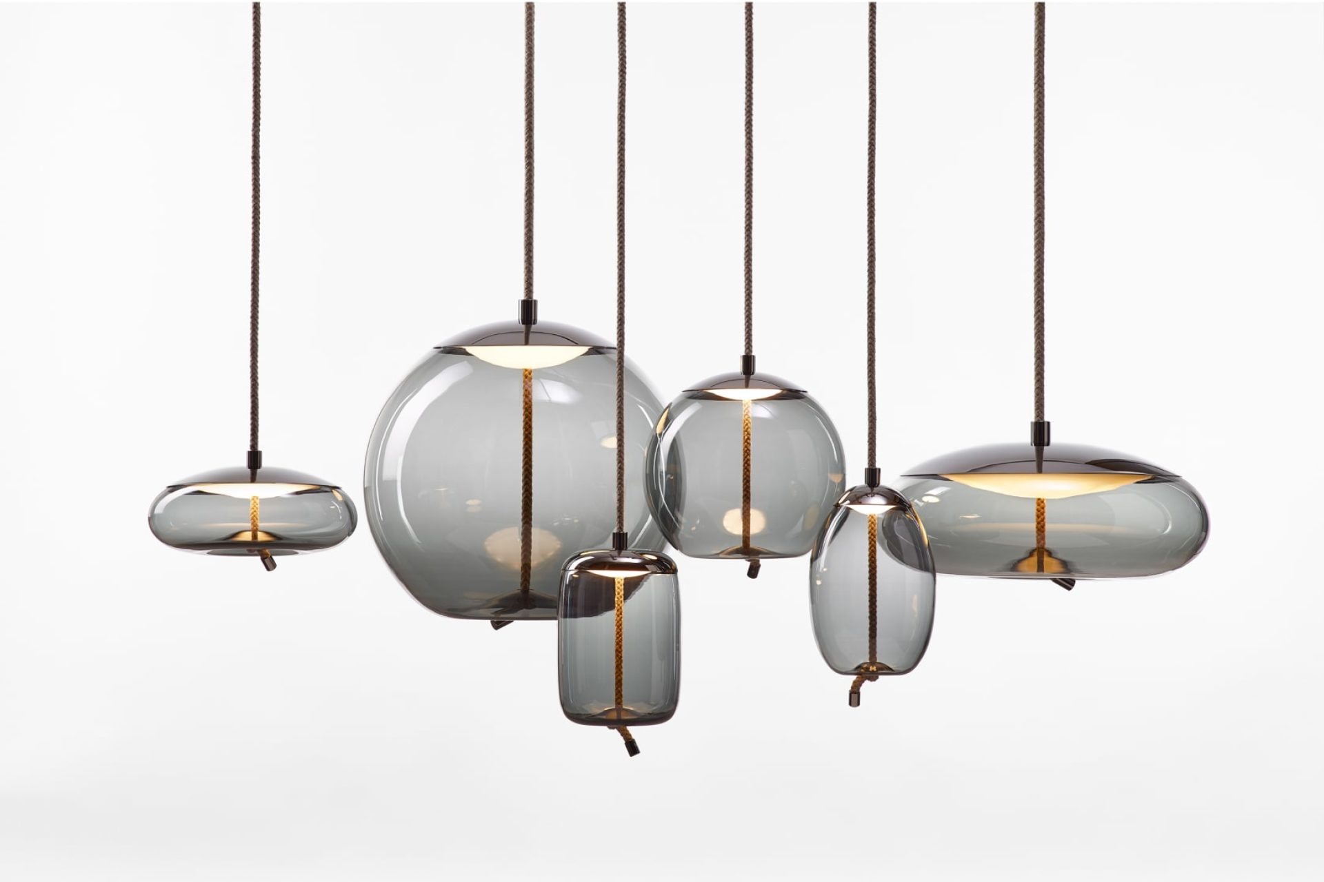 Composition de six lampes suspendues en verre de forme et taille variées