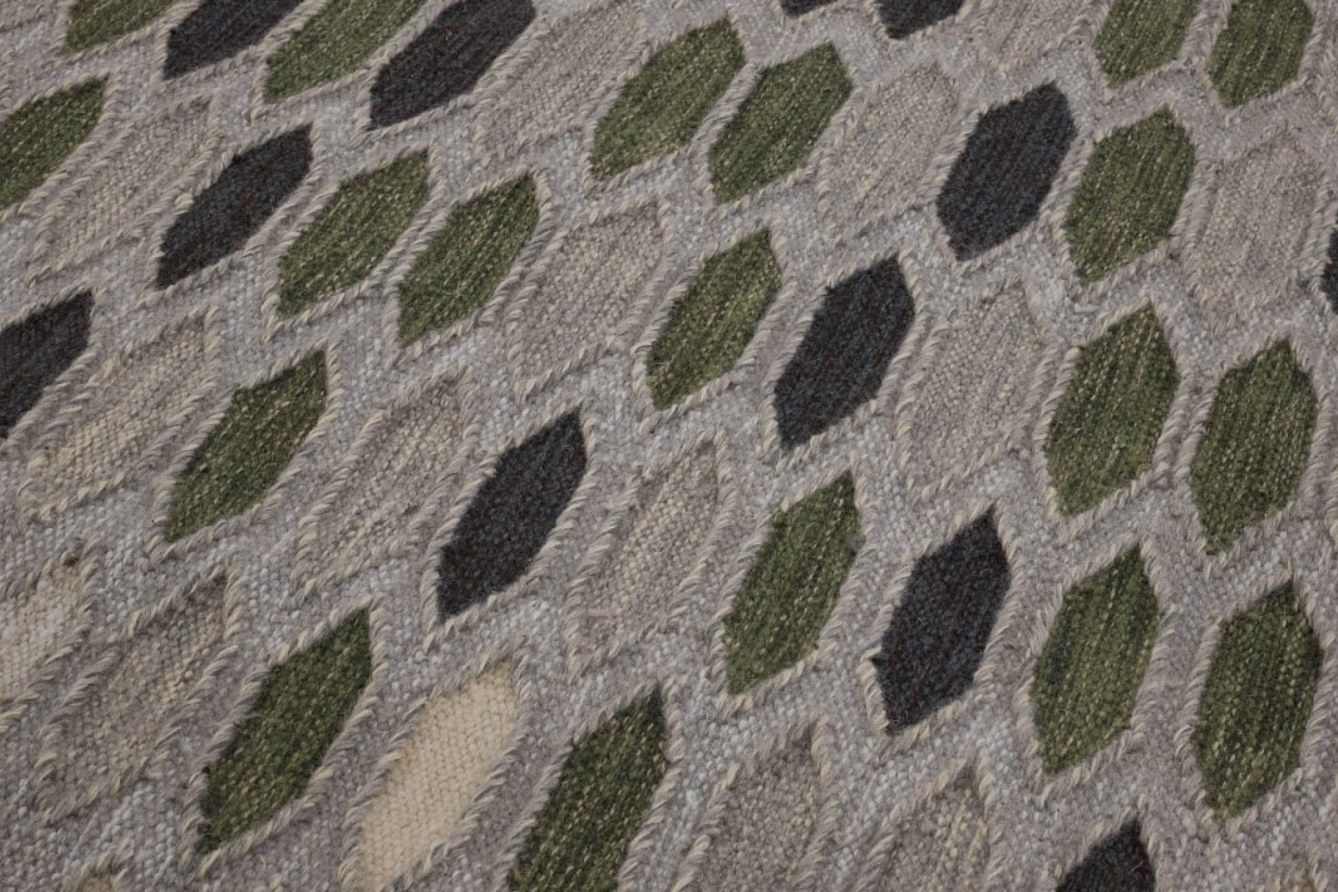 Aperçu d'une partie de tapis design avec des losange dans des tons beige, vert et gris