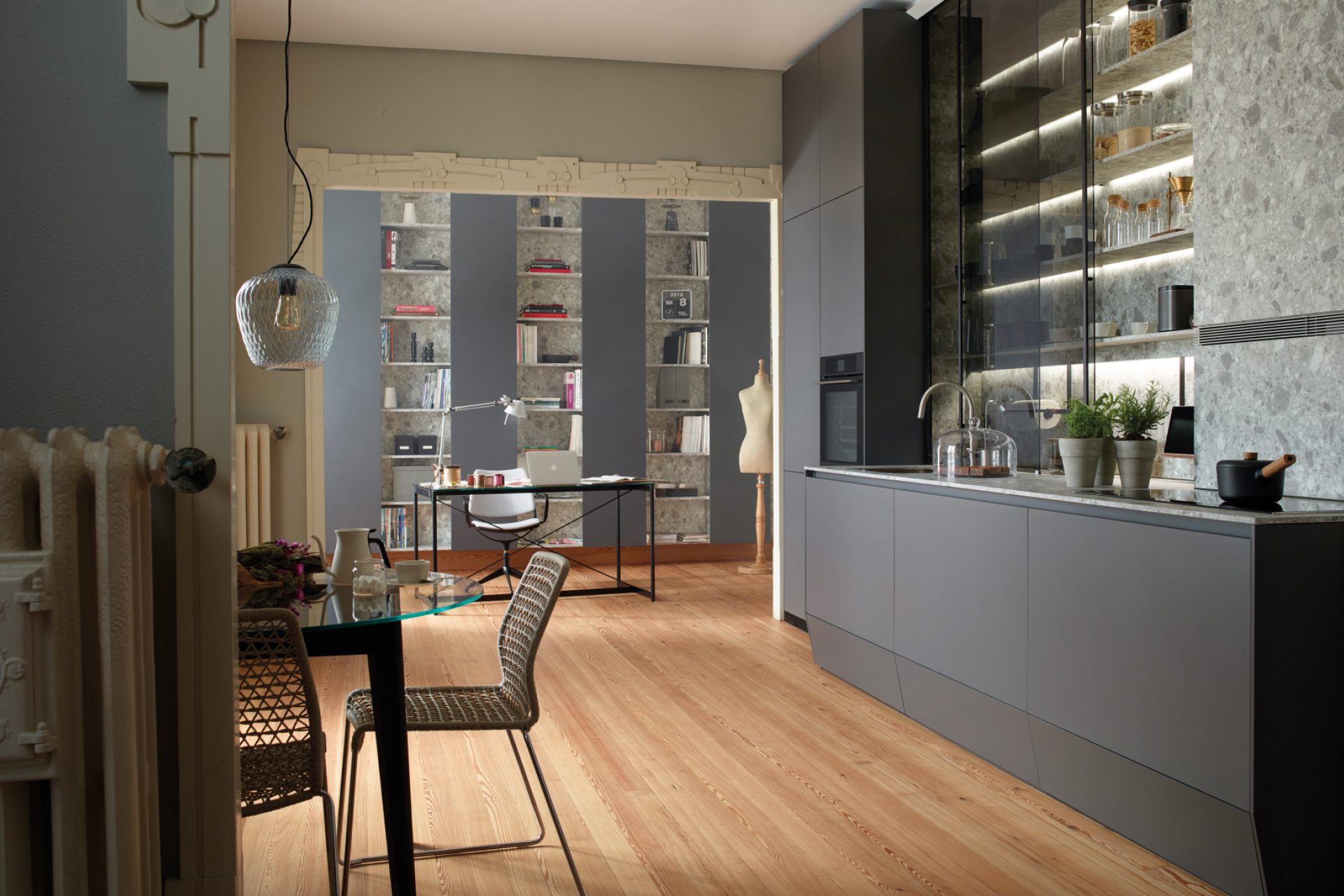 Cuisine linéaire grise avec meubles colonne, étagères et meubles bas avec coffre plinthe, ouverte sur l'espace de jour