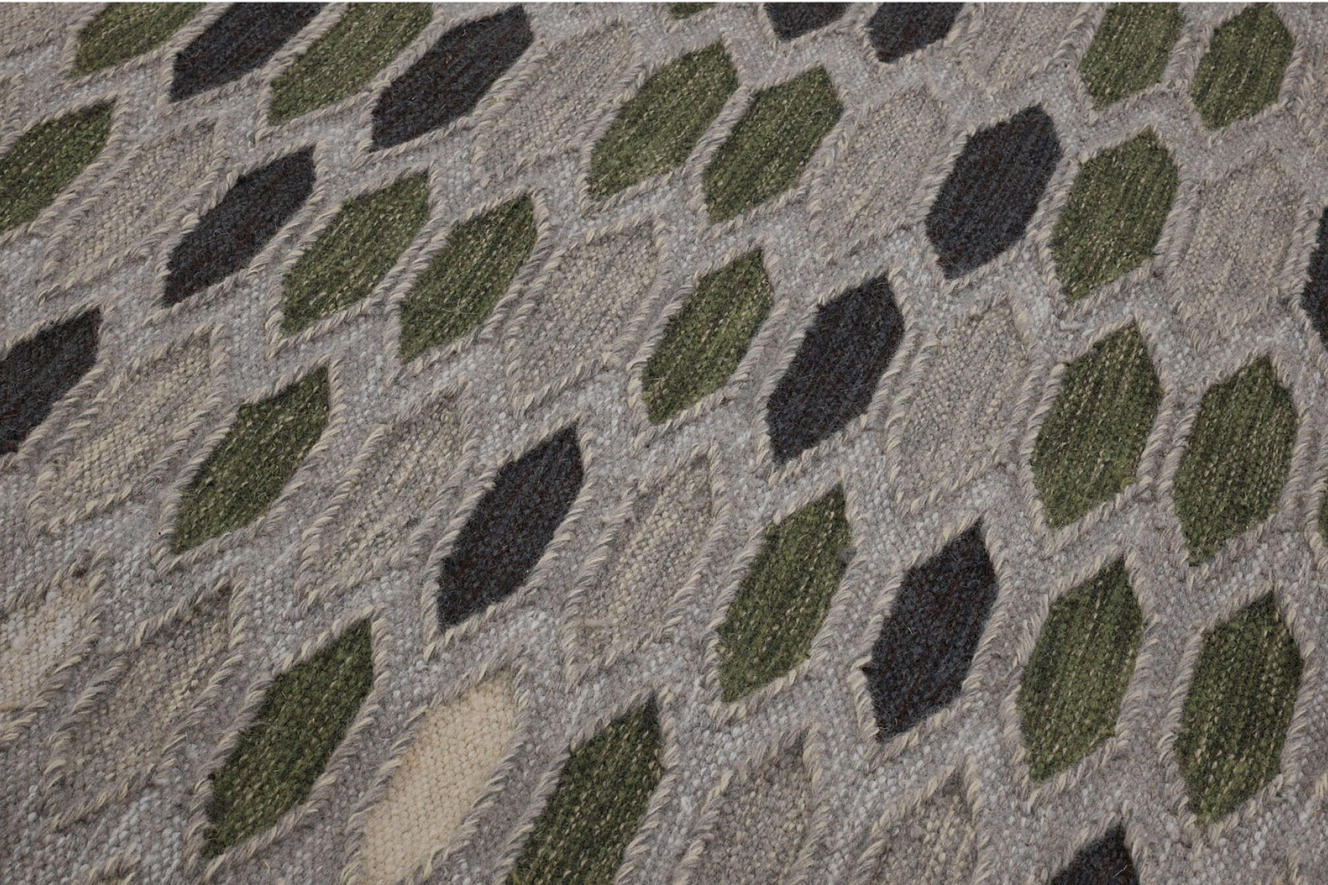 Aperçu d'une partie de tapis design avec des losange dans des tons beige, vert et gris